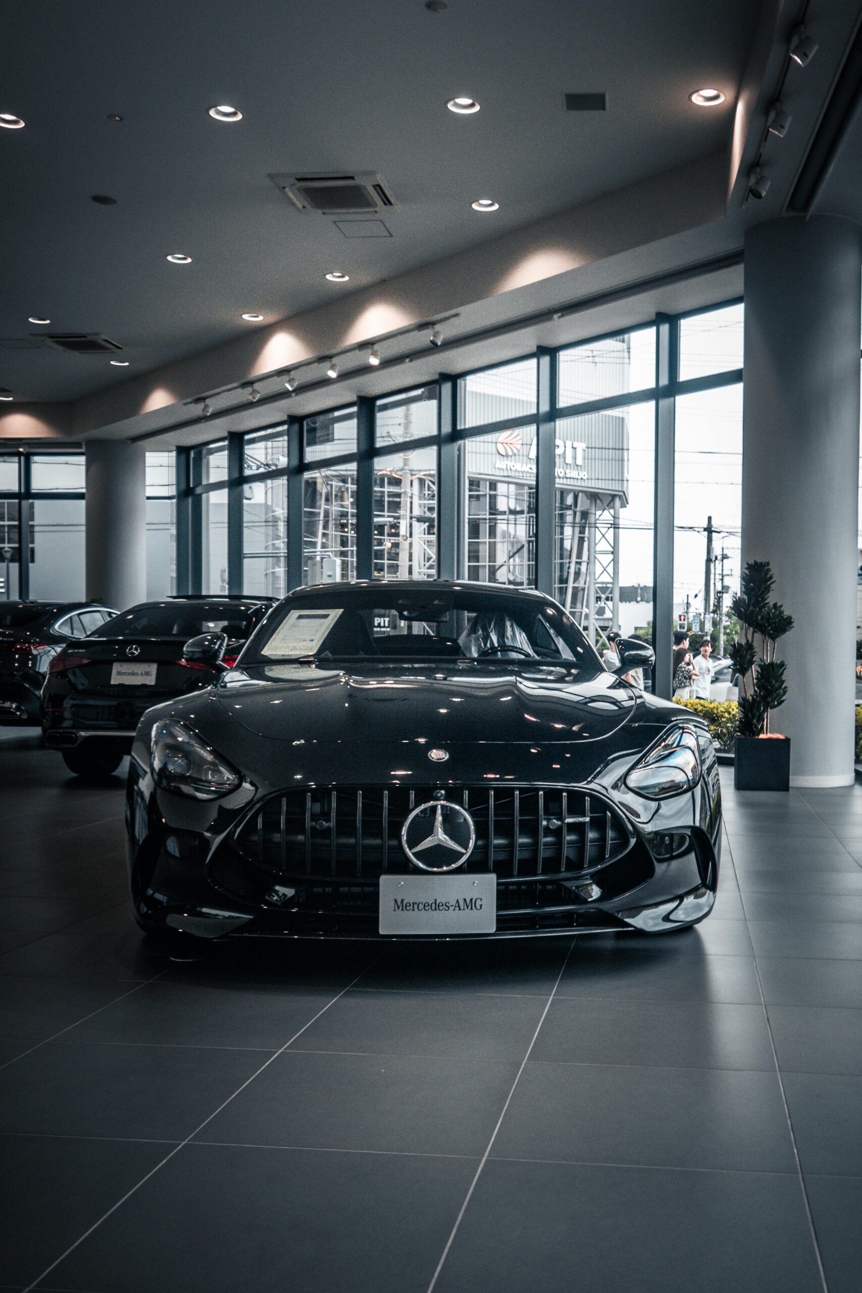 A sleek Mercedes-AMG showcased in a modern Kyoto showroom, highlighting luxury and automotive design.